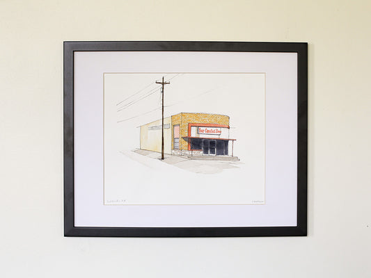 Framed original watercolor art on white wall with black wood frame.