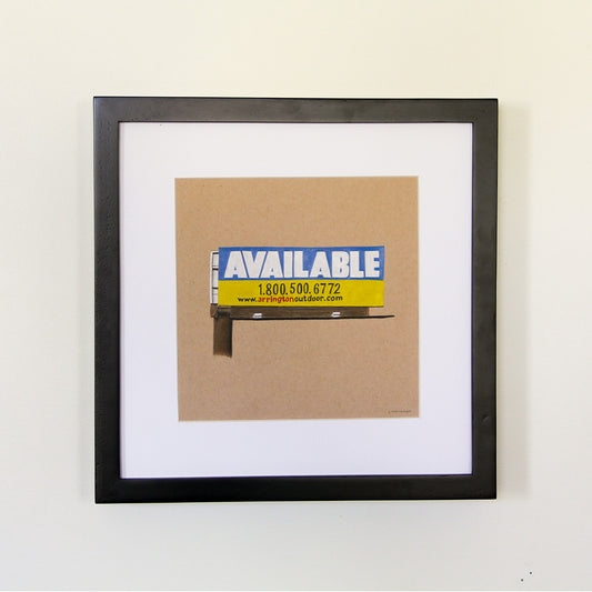 Framed artwork hung on white wall. Colored pencil drawing on tan toned paper of a blue and yellow billboard road sign with a 2 inch white matte around the art in a black wood frame.