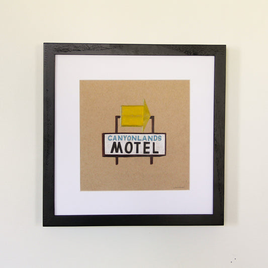 Framed artwork hung on white wall. Colored pencil drawing on tan toned paper of a yellow and light blue motel road sign with a 2 inch white matte around the art in a black wood frame. 