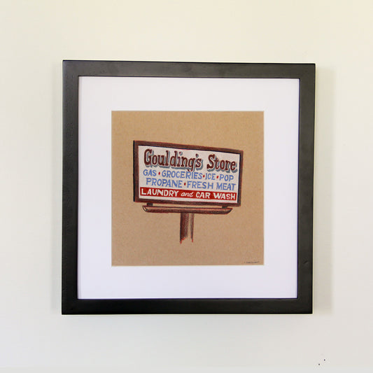 Framed artwork hung on white wall. Colored pencil drawing on tan toned paper of a brown and white road store sign with a 2 inch white matte around the art in a black wood frame. 