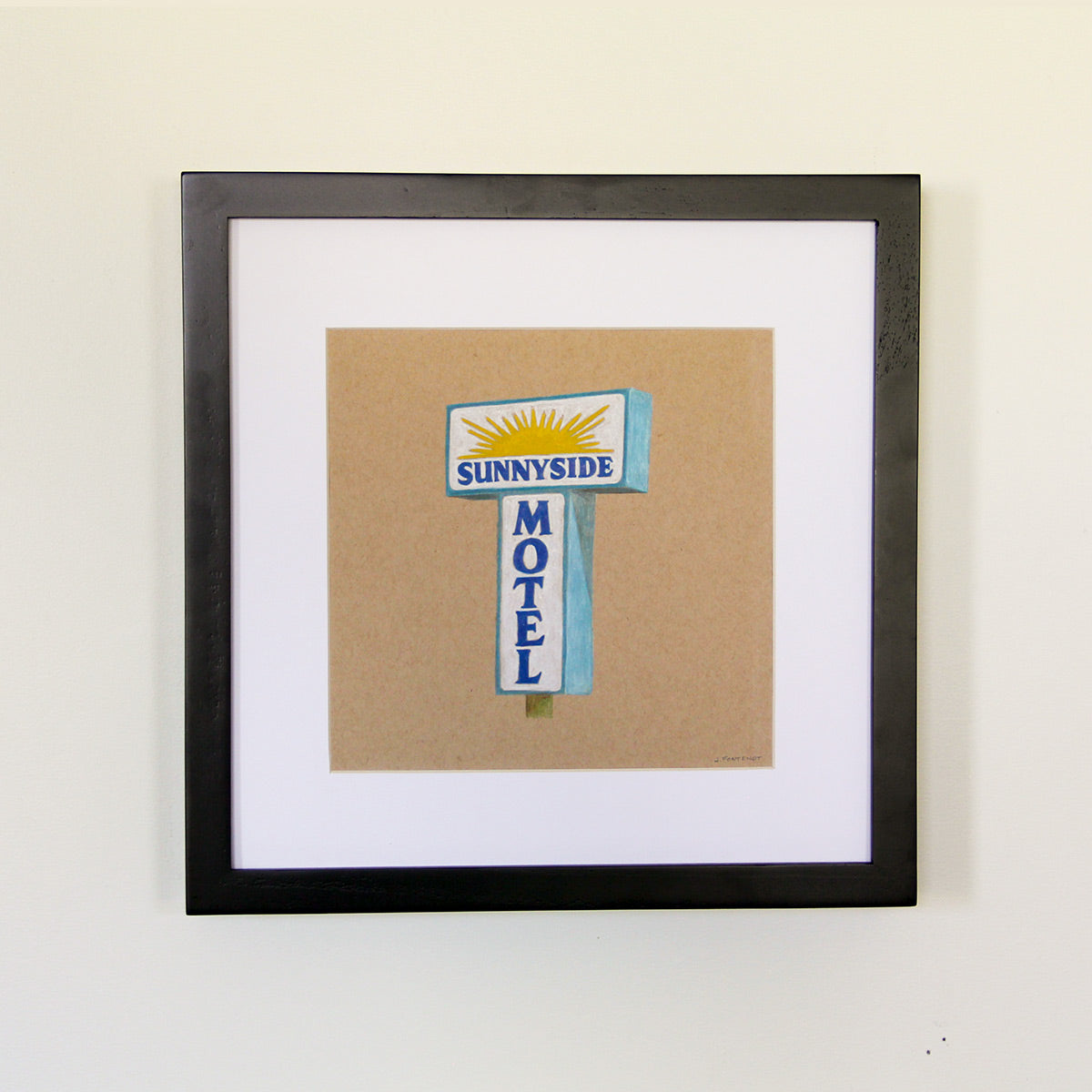 Framed artwork hung on white wall. Colored pencil drawing on tan toned paper of a blue and yellow motel sign with a 2 inch white matte around the art in a black wood frame. 