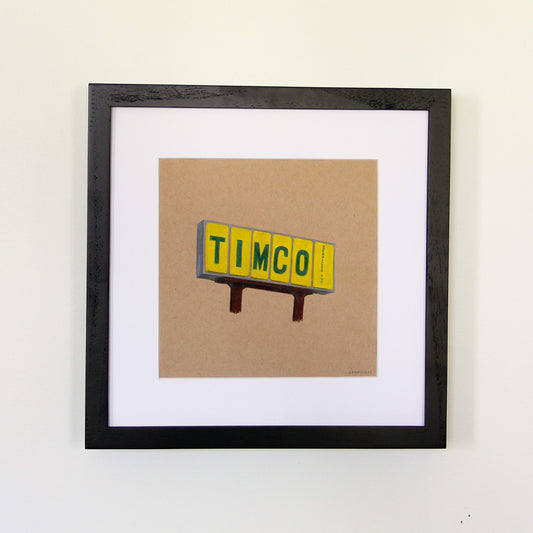 Framed artwork hung on white wall. Colored pencil drawing on tan toned paper of a yellow and green road sign with a 2 inch white matte around the art in a black wood frame. 