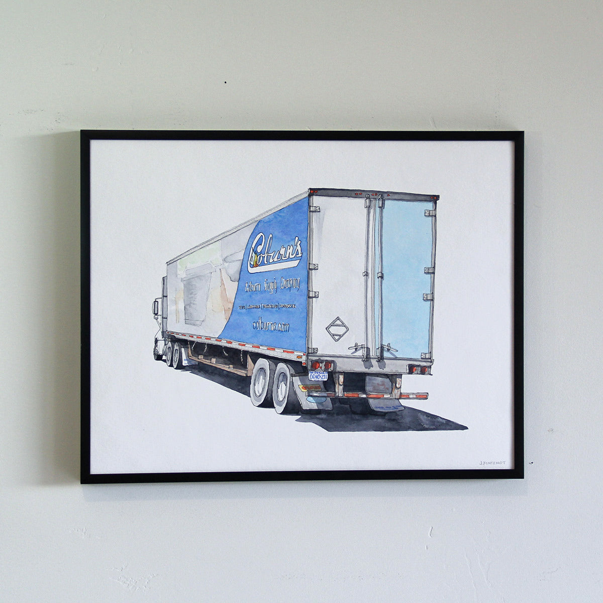 Framed original artwork hung on the wall in thin black metal frame. Watercolor painting of Coburn's truck