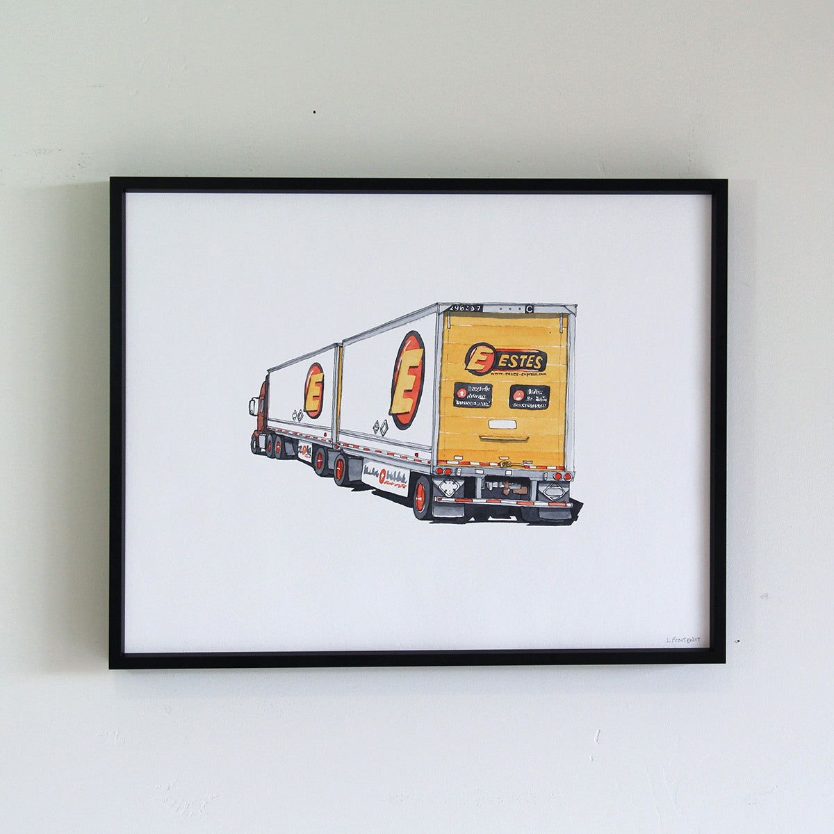 Framed original artwork hung on wall in thin black metal frame. Watercolor painting of Estes cargo truck