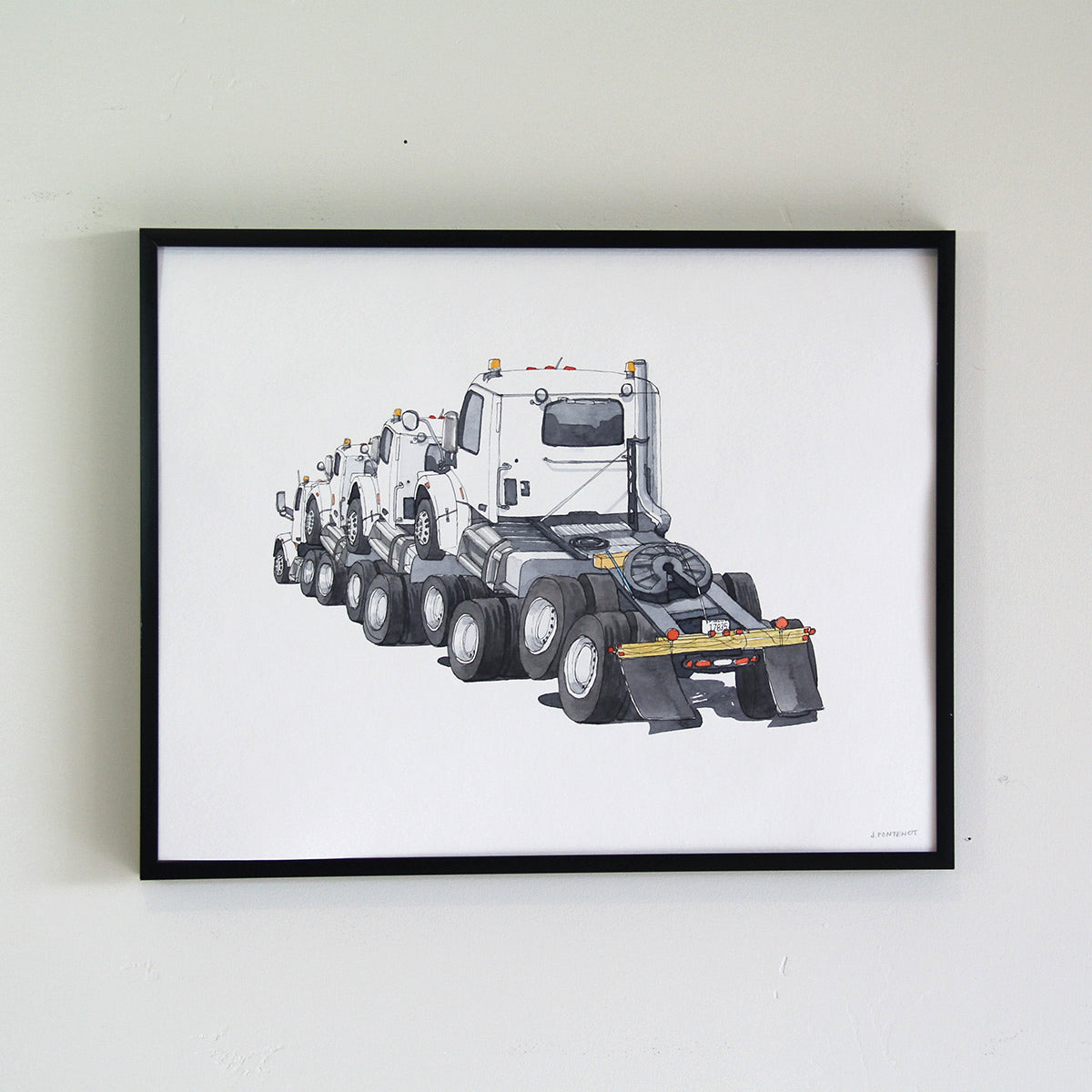 Framed original art hung on the wall with thin black metal frame. Watercolor painting of stacked truck cabs.