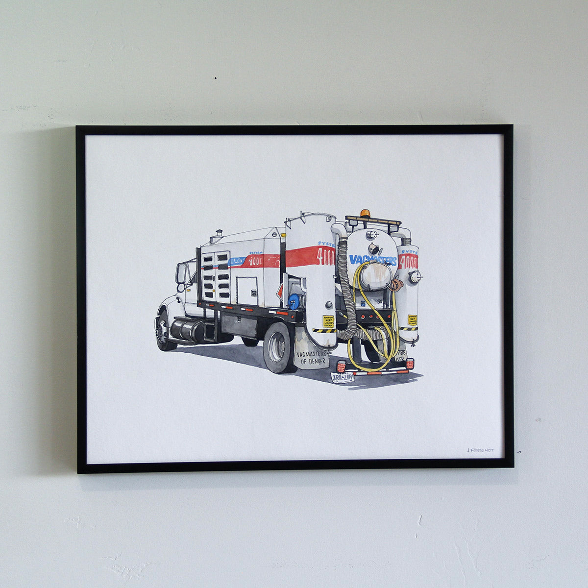 Framed original artwork hung on wall in thin black metal frame. Watercolor painting of Vacmasters truck