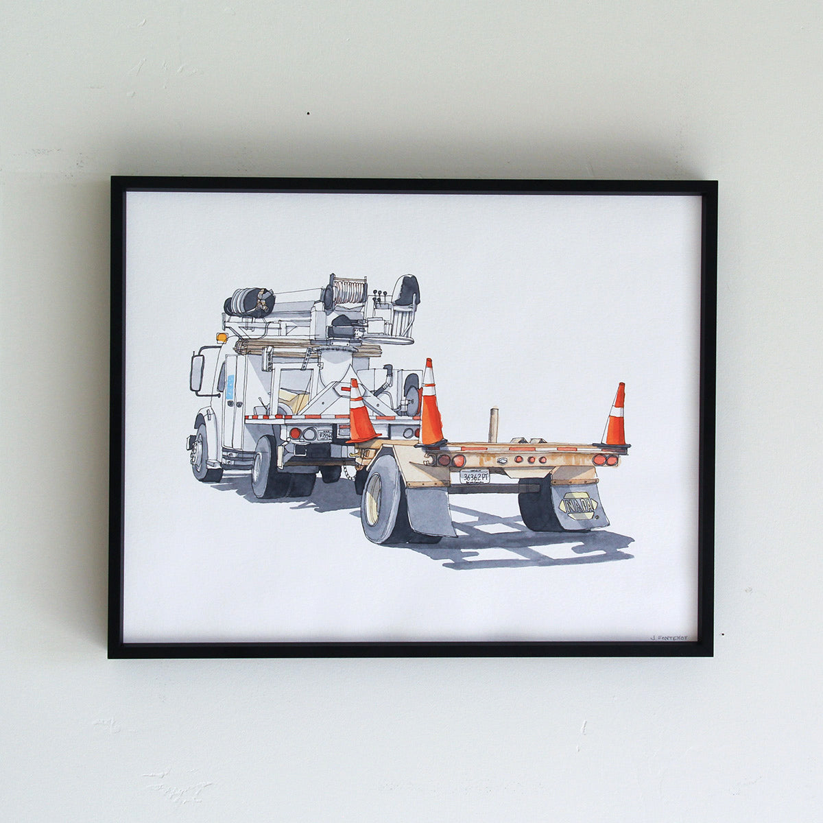 Framed original artwork hung on wall in thin black metal frame. Watercolor painting of work truck with cones