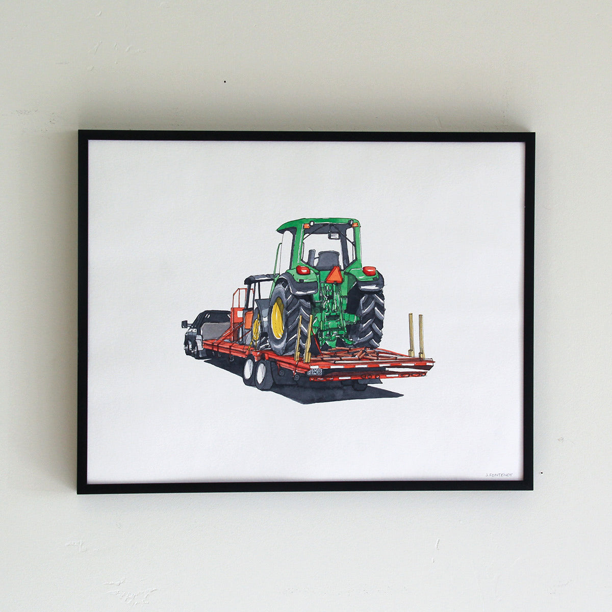 Framed original artwork hung on wall in thin black metal frame. Watercolor painting of green tractor on flatbed