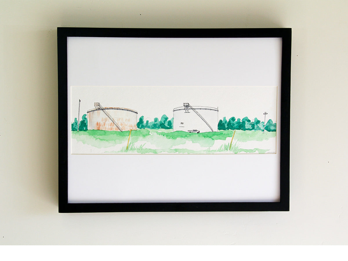 Framed original watercolor art on white wall with black wood frame.